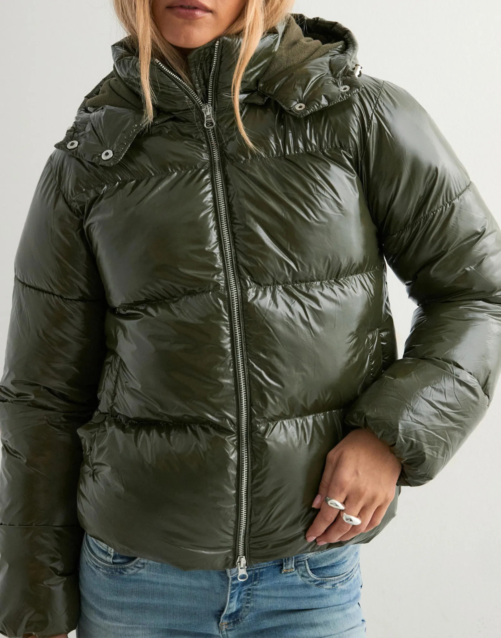 Close-up of green puffer jacket zip and hood detail
