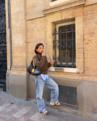 Brown suede bomber jacket, model leaning against wall, front view