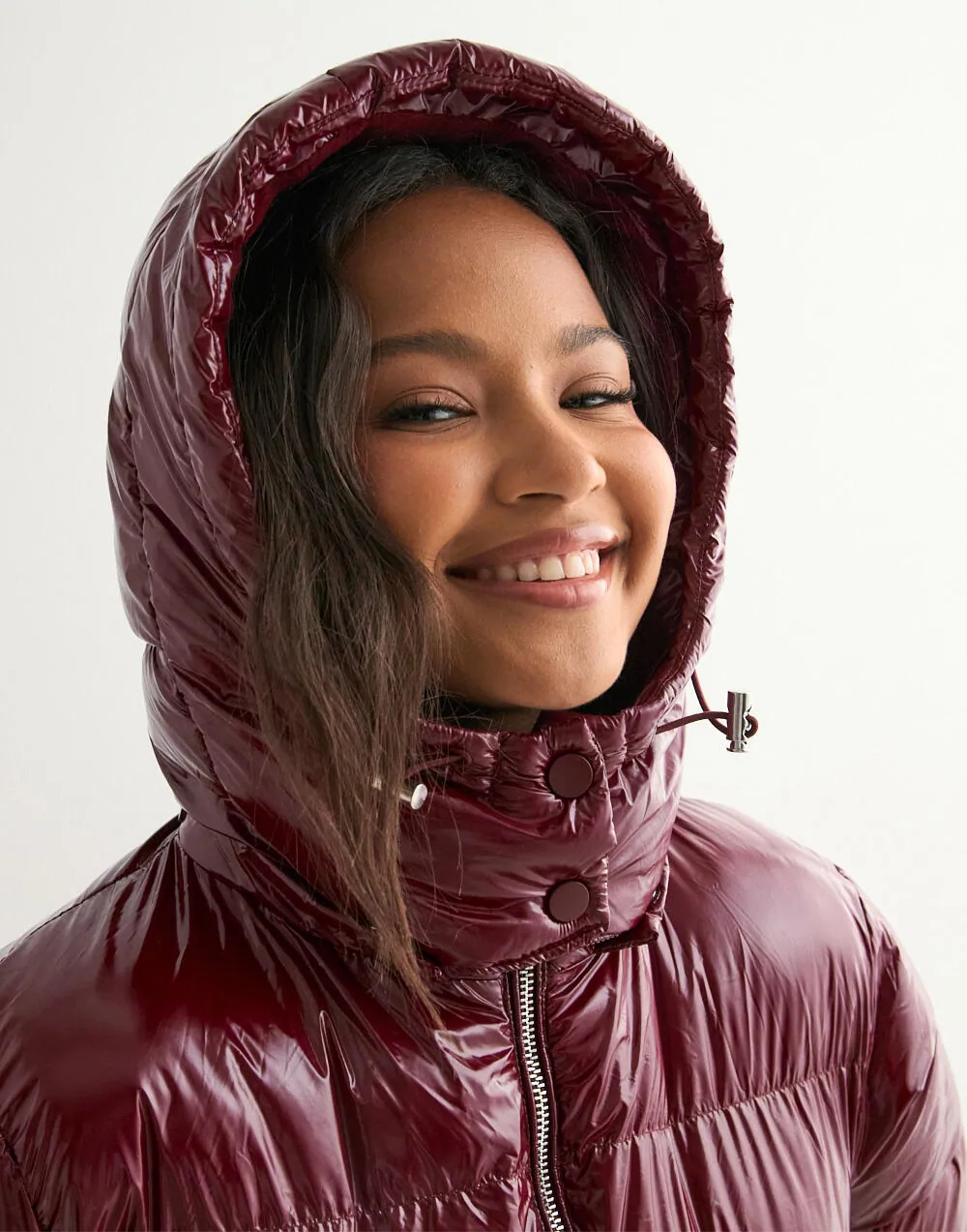 Close-up of wine red puffer jacket hood on model