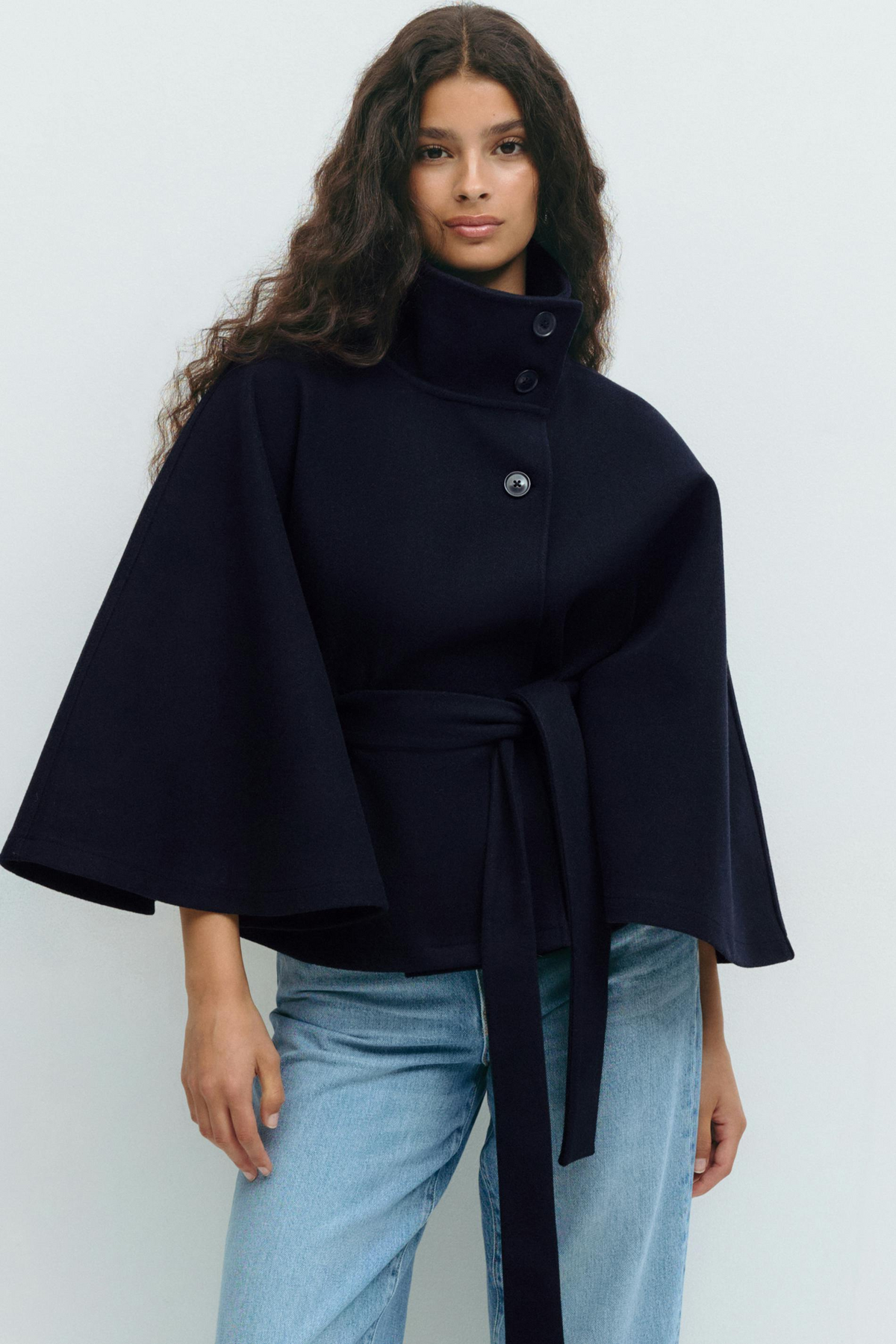 Midnight blue belted cape jacket, close-up front view on model