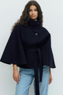 Midnight blue belted cape jacket, close-up front view on model