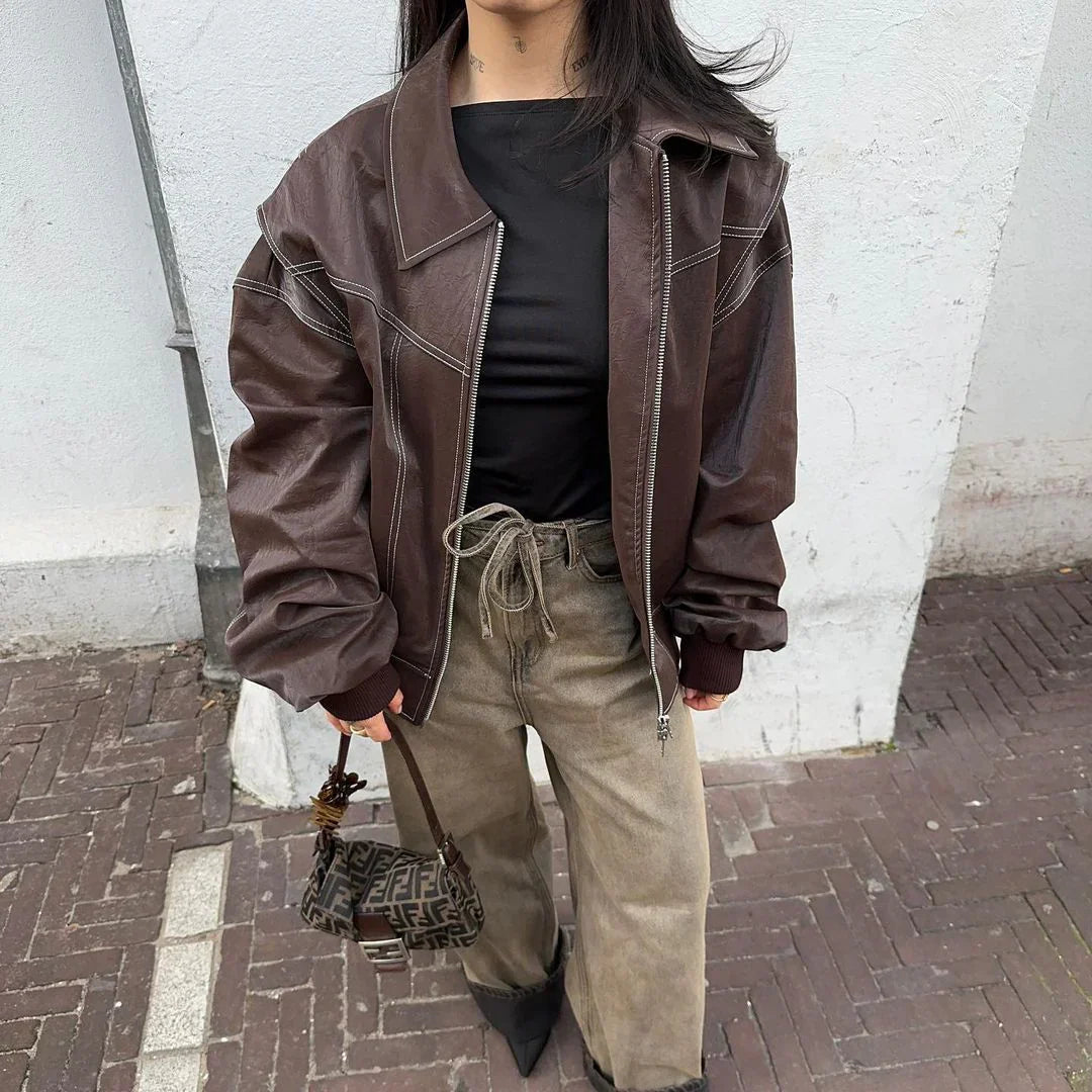 Brown oversized contrast-stitch jacket, close-up front view with handbag