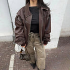 Brown oversized contrast-stitch jacket, close-up front view with handbag