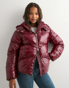 Close-up of wine red glossy hooded puffer jacket on model