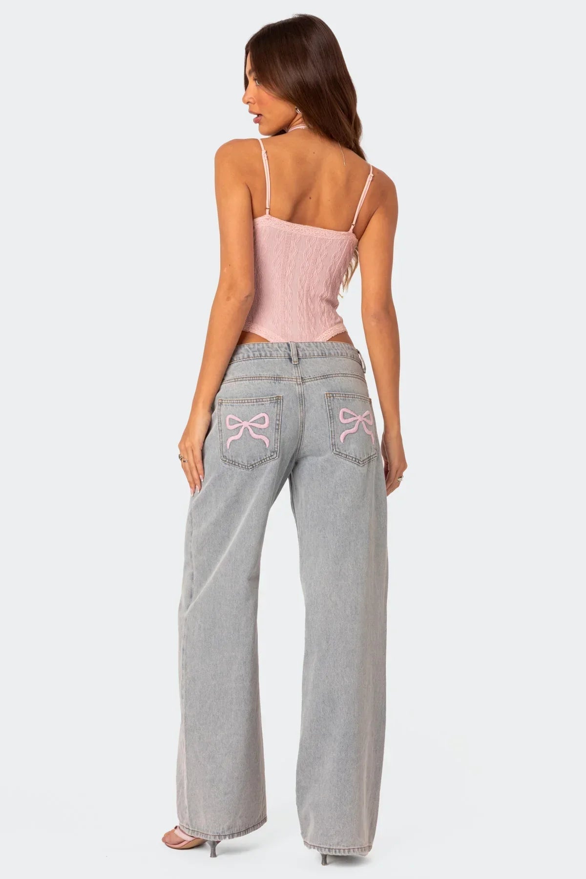 Grey wide-leg jeans with pink bow pocket embroidery, back view on model