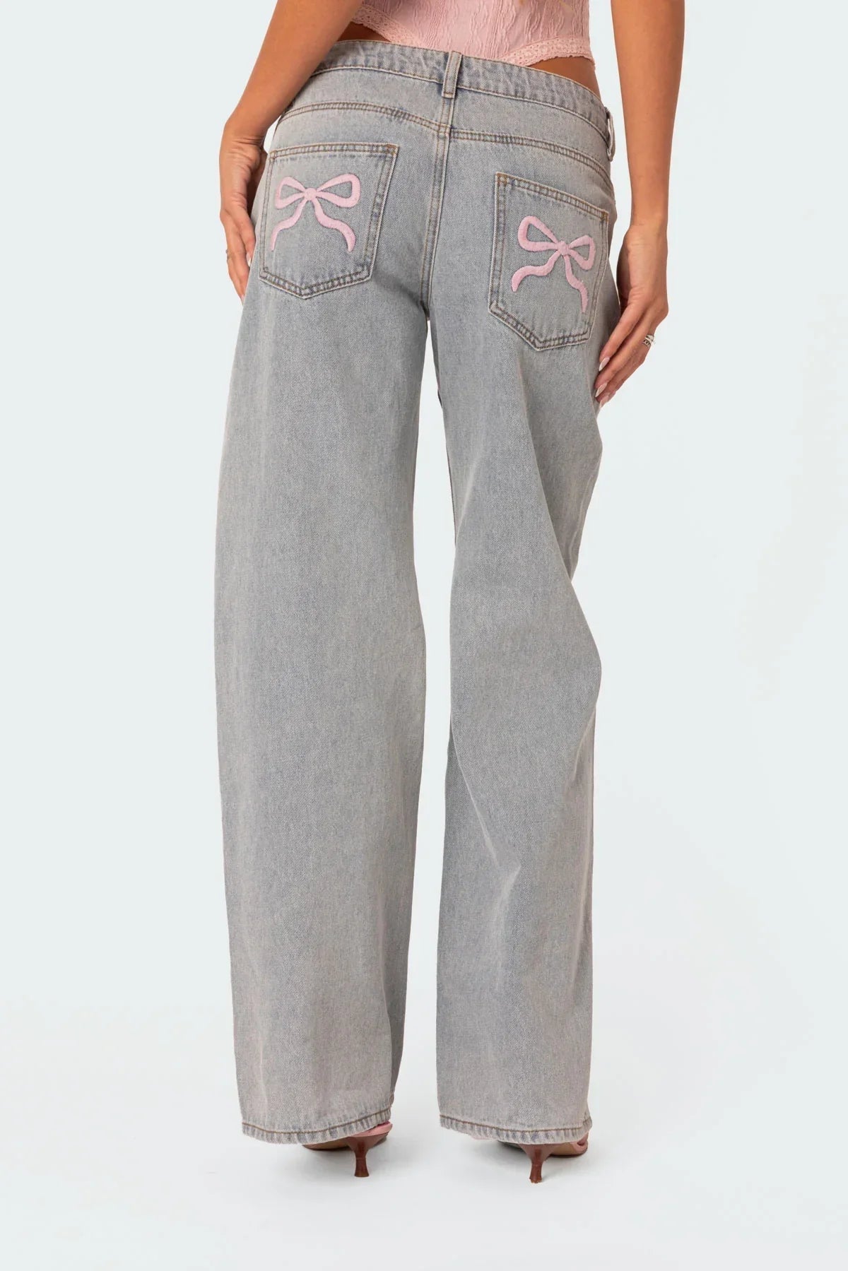 Grey wide-leg jeans, close-up of pink bow pocket embroidery