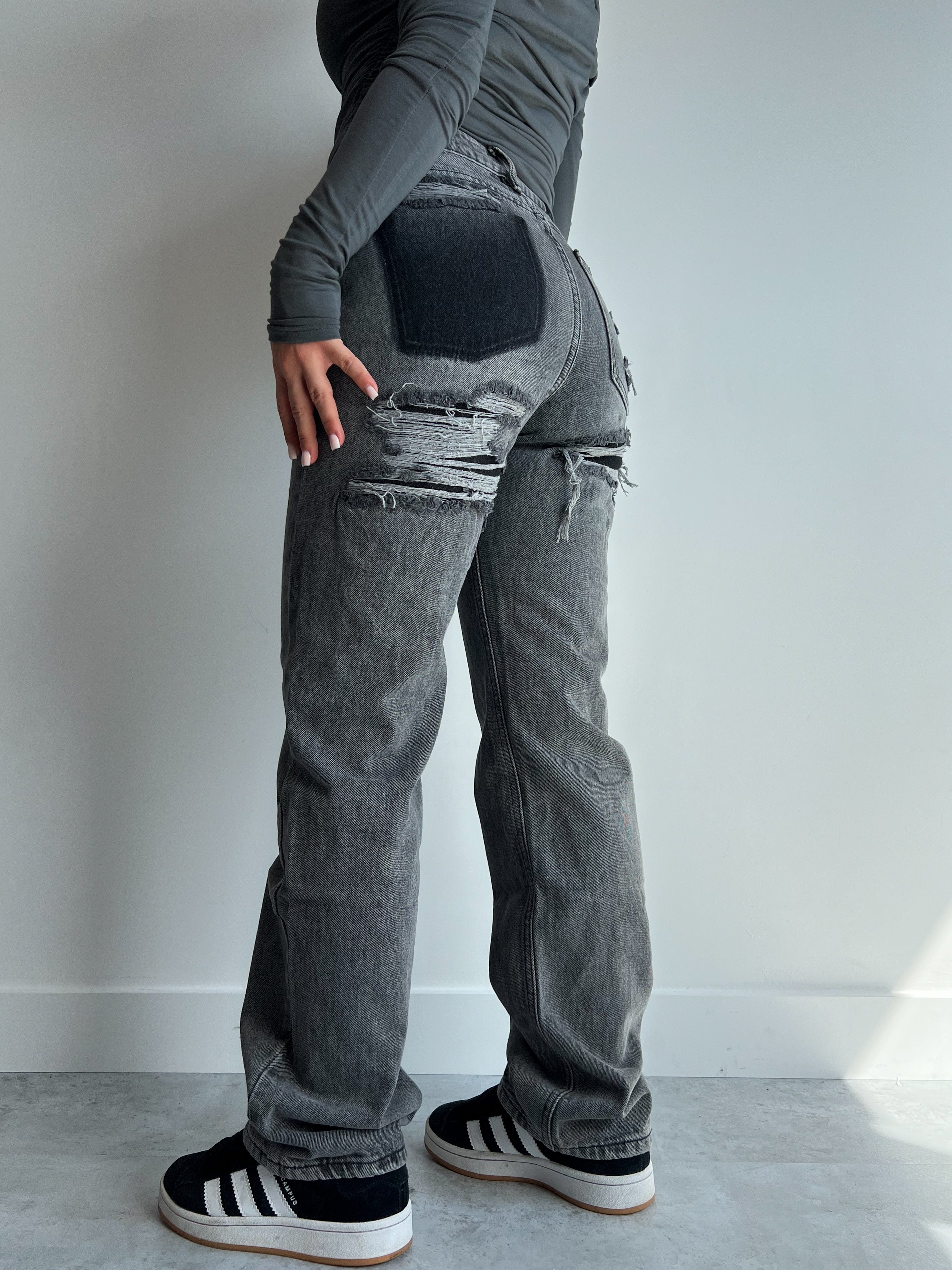 Grey distressed wide-leg jeans with ripped thigh, back view on model