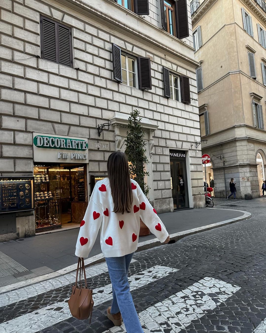 Ivory jumper with red heart print, back view on model walking