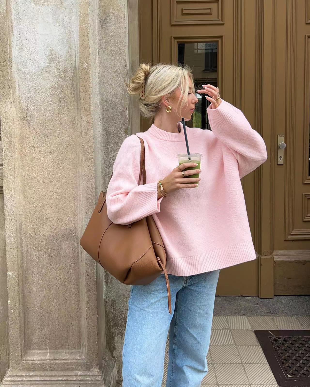 Pink oversized jumper styled with jeans, side view on model