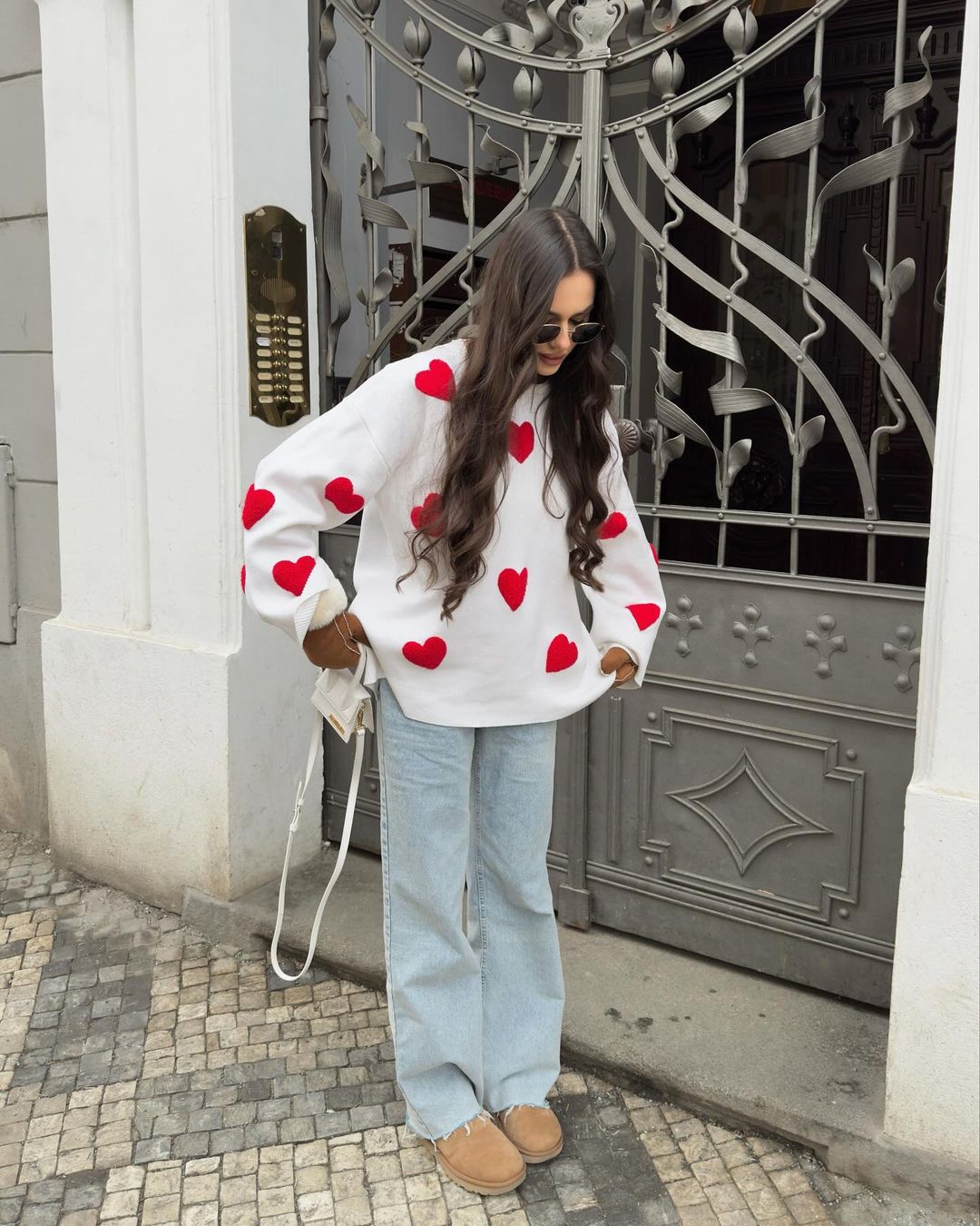 Ivory jumper with red heart print, styled with jeans, full length