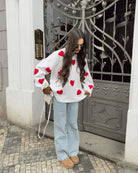 Ivory jumper with red heart print, styled with jeans, full length