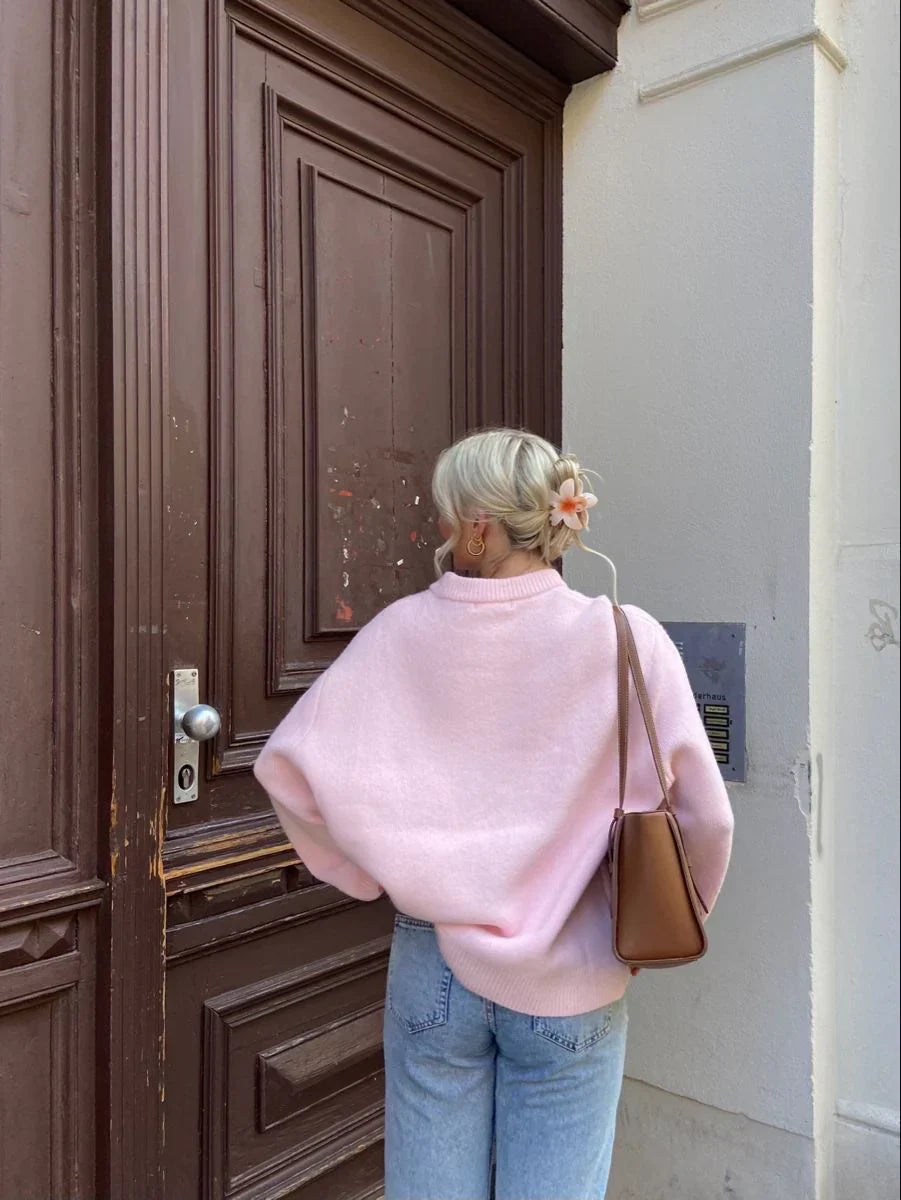 Pink oversized jumper, back view on model at doorway