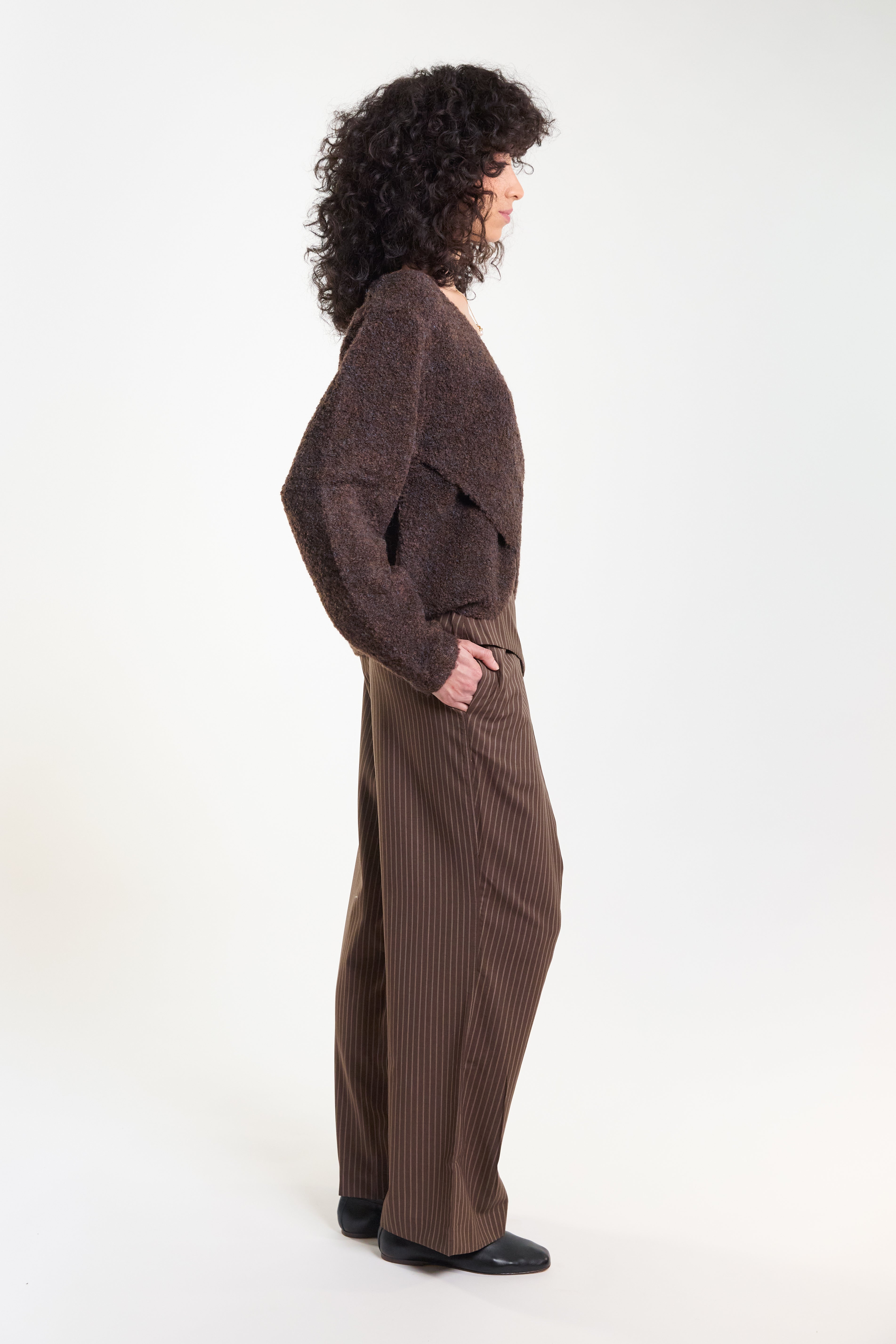 Brown pinstripe tailored trousers, side view on model