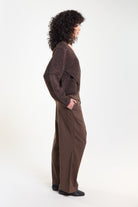 Brown pinstripe tailored trousers, side view on model