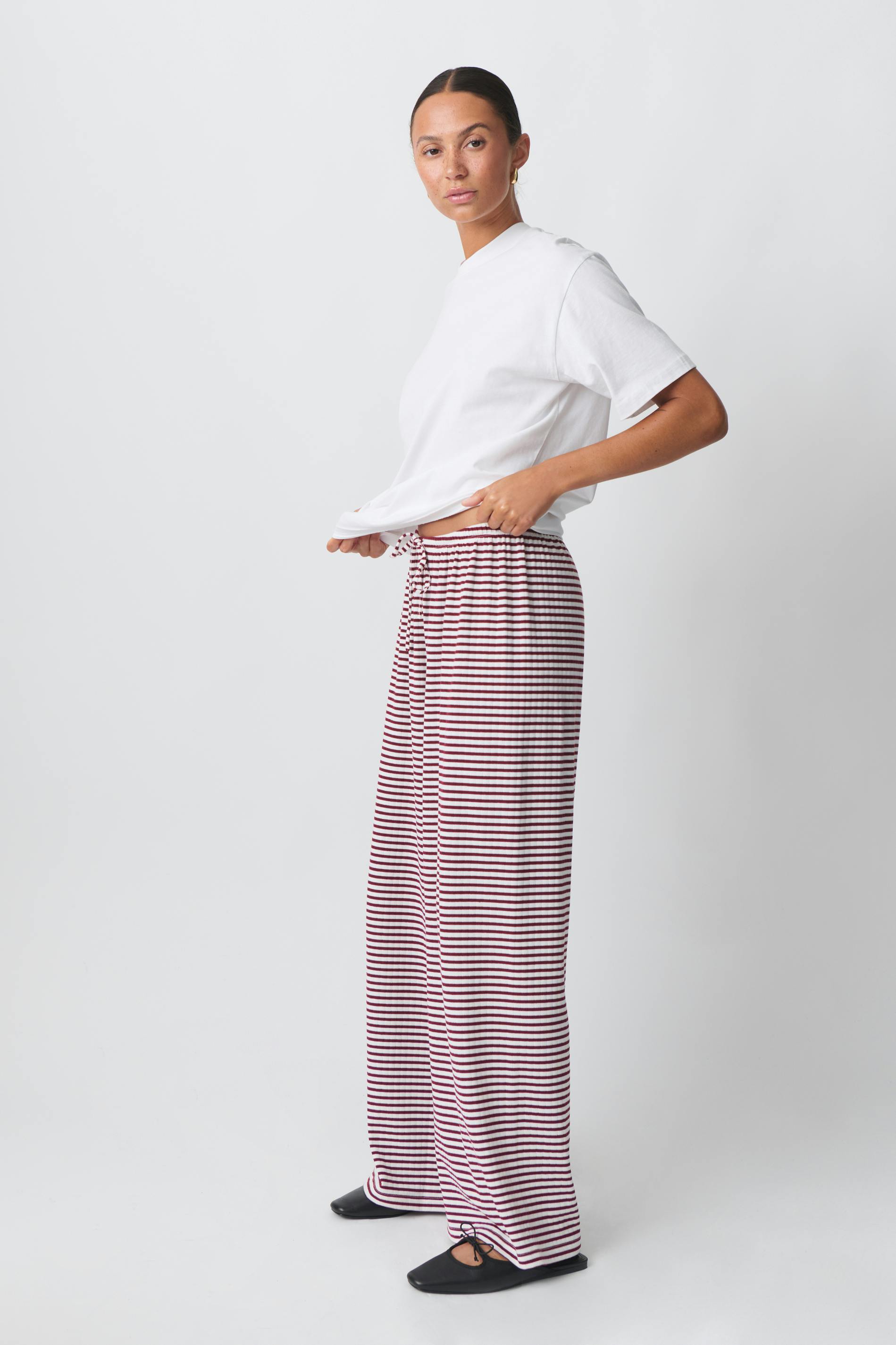 Red and white striped wide-leg trousers, side view on model