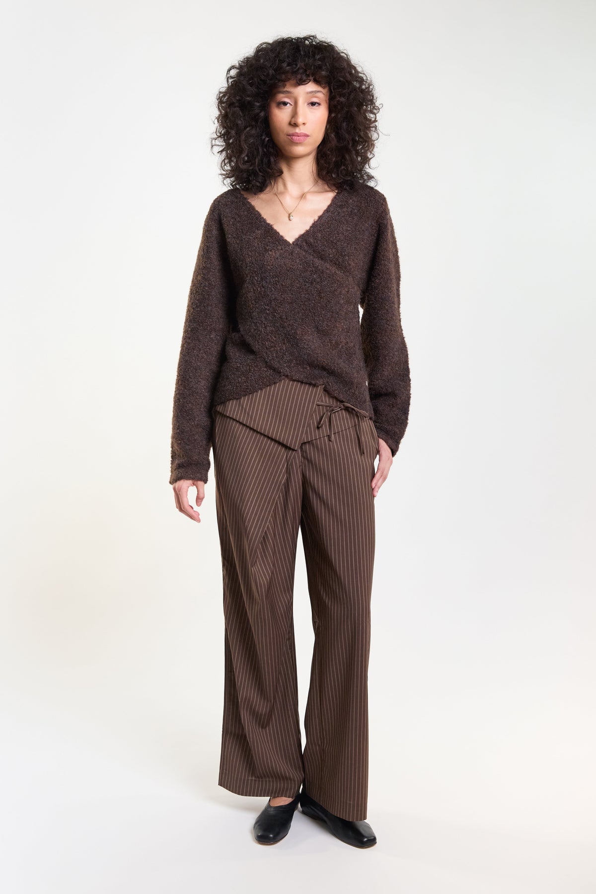 Brown pinstripe tailored trousers with jumper, full length on model