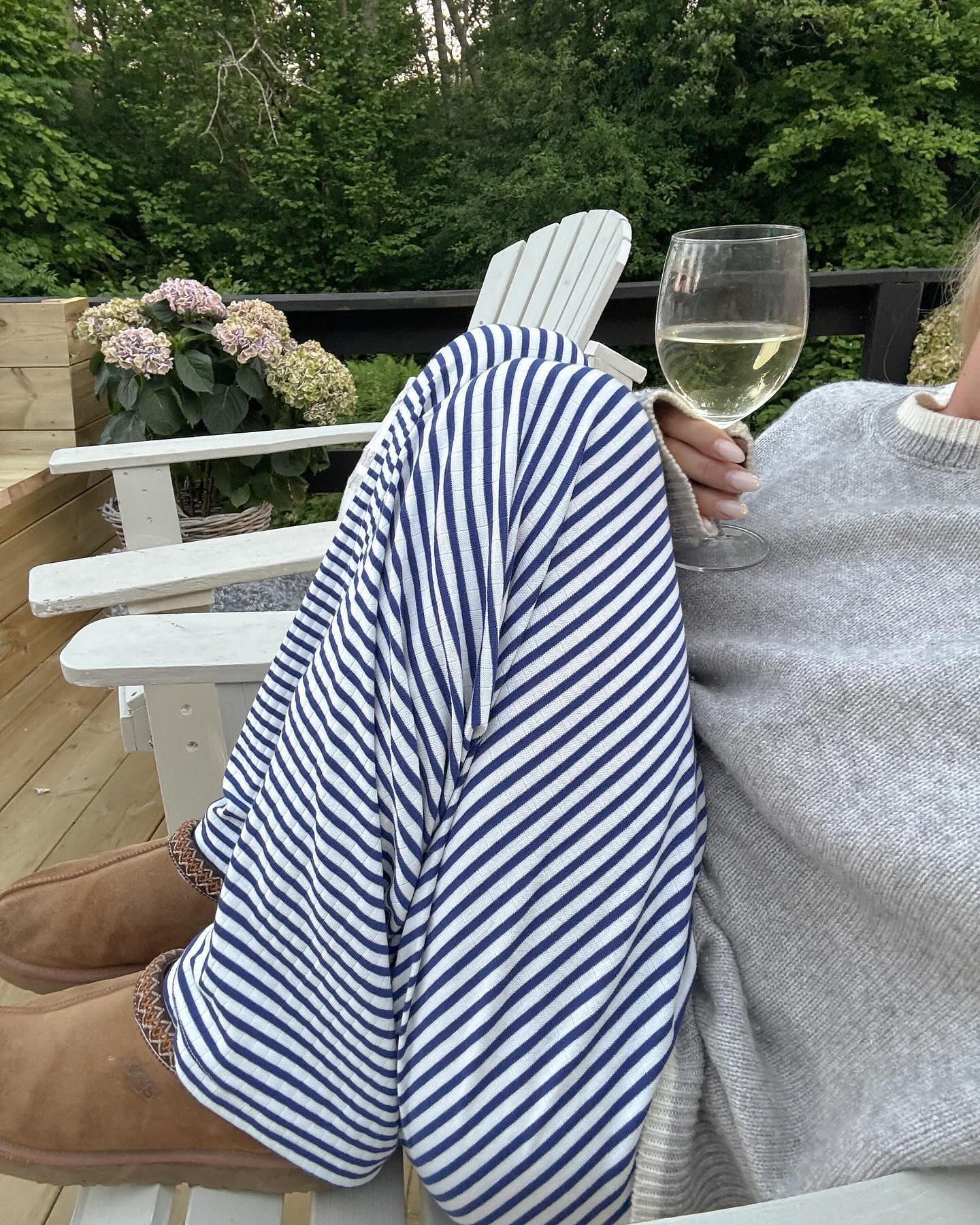 Navy and white striped wide-leg trousers, close-up seated on model
