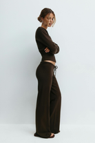 Brown knitted cardigan and trousers set on model, side view