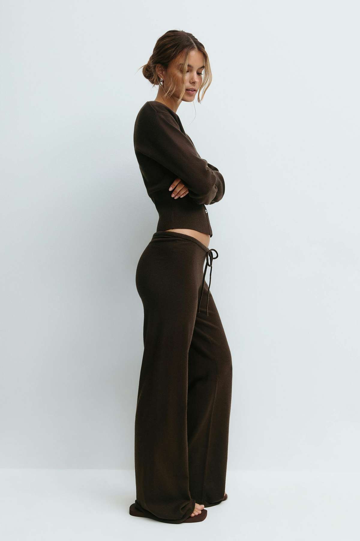 Brown knitted cardigan and trousers set on model, side view