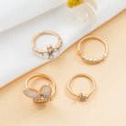 Gold butterfly ring set, four rings flat lay on white fabric