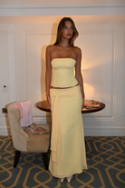 Lemon dot corset top and wrap maxi skirt, front view in hotel room