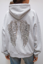 Detail of sequin angel wings on back of grey hoodie