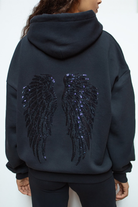 Detail of sequin angel wings on back of navy hoodie