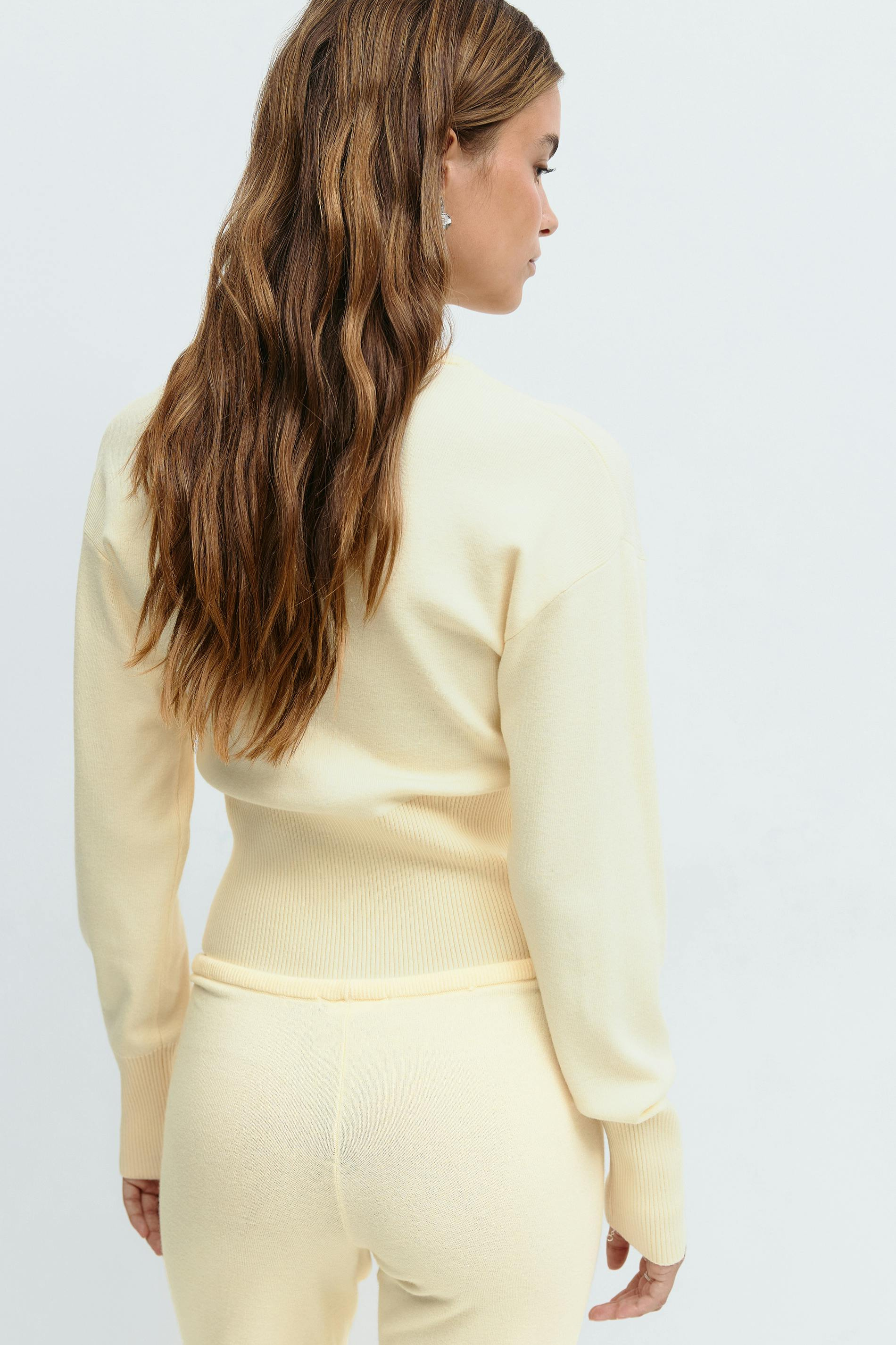 Yellow knitted cardigan and trousers set, close crop back view