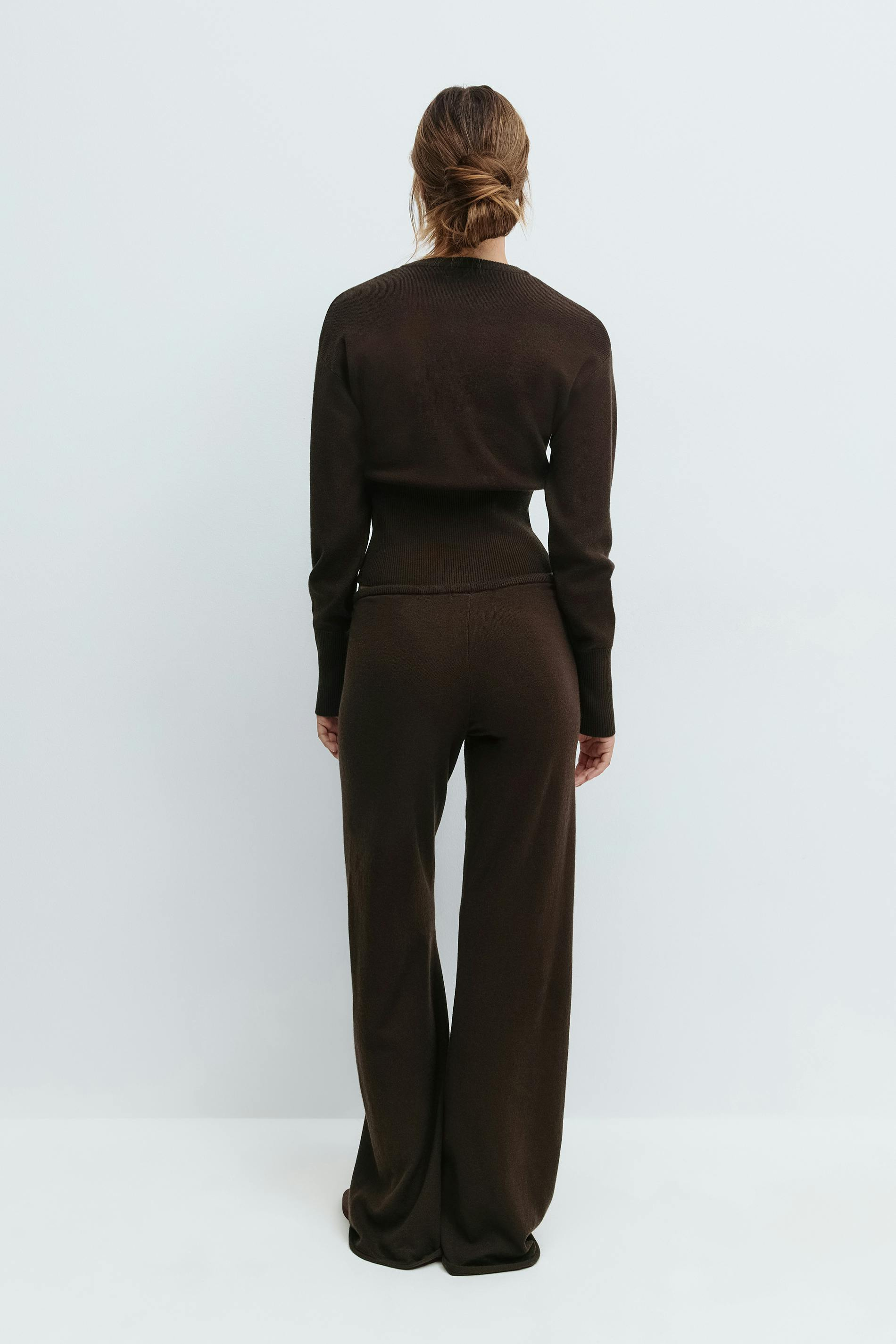 Brown knitted cardigan and trousers set on model, back view