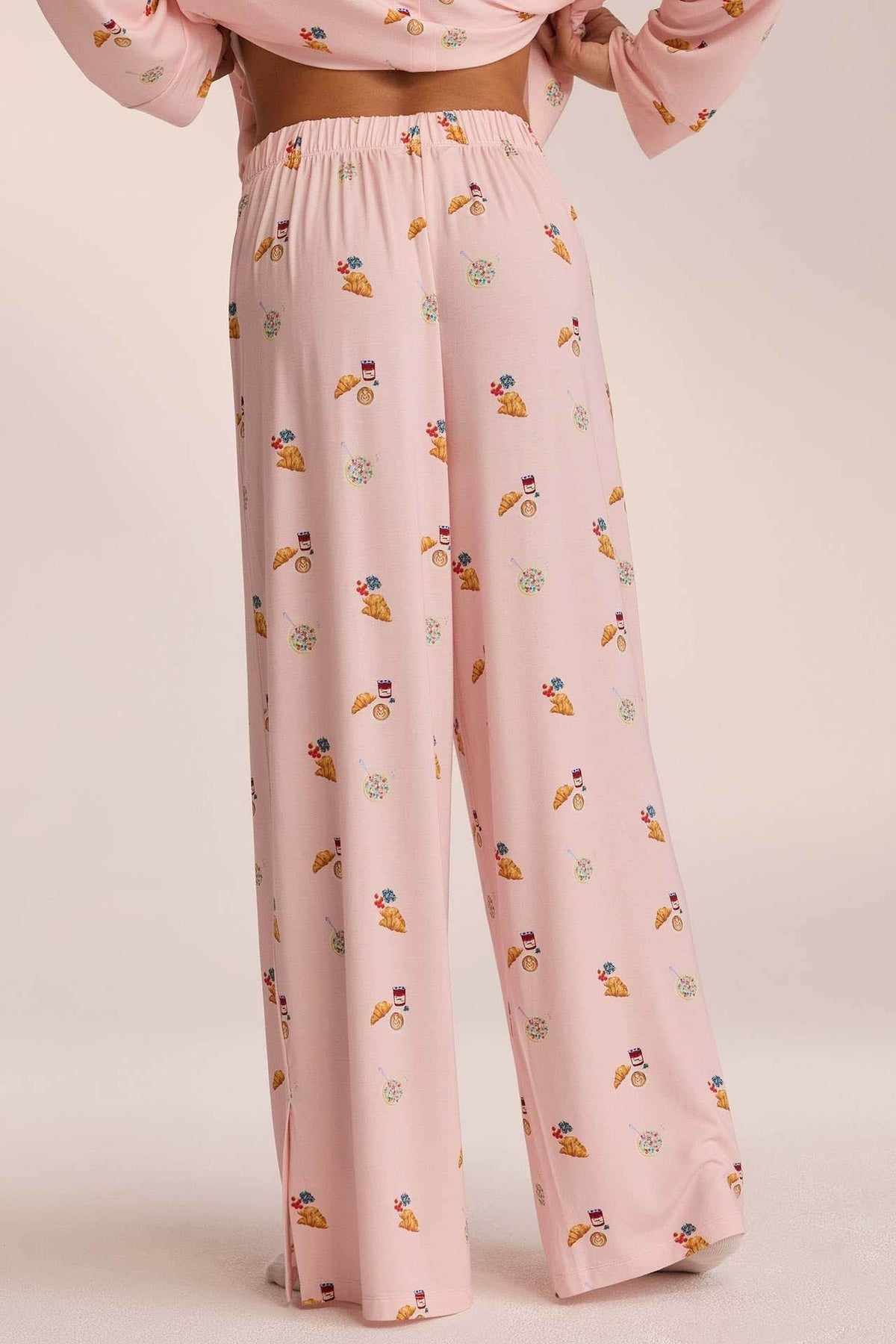 Close-up of pink breakfast-print pyjama trousers, back view on model