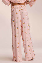 Close-up of pink breakfast-print pyjama trousers, back view on model