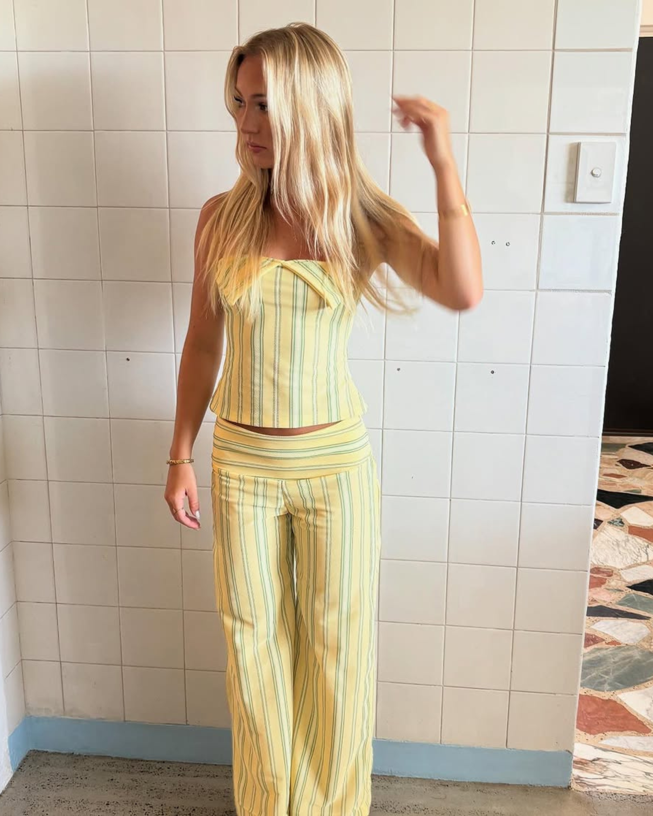 Yellow stripe halter top and trousers set, model turned to side