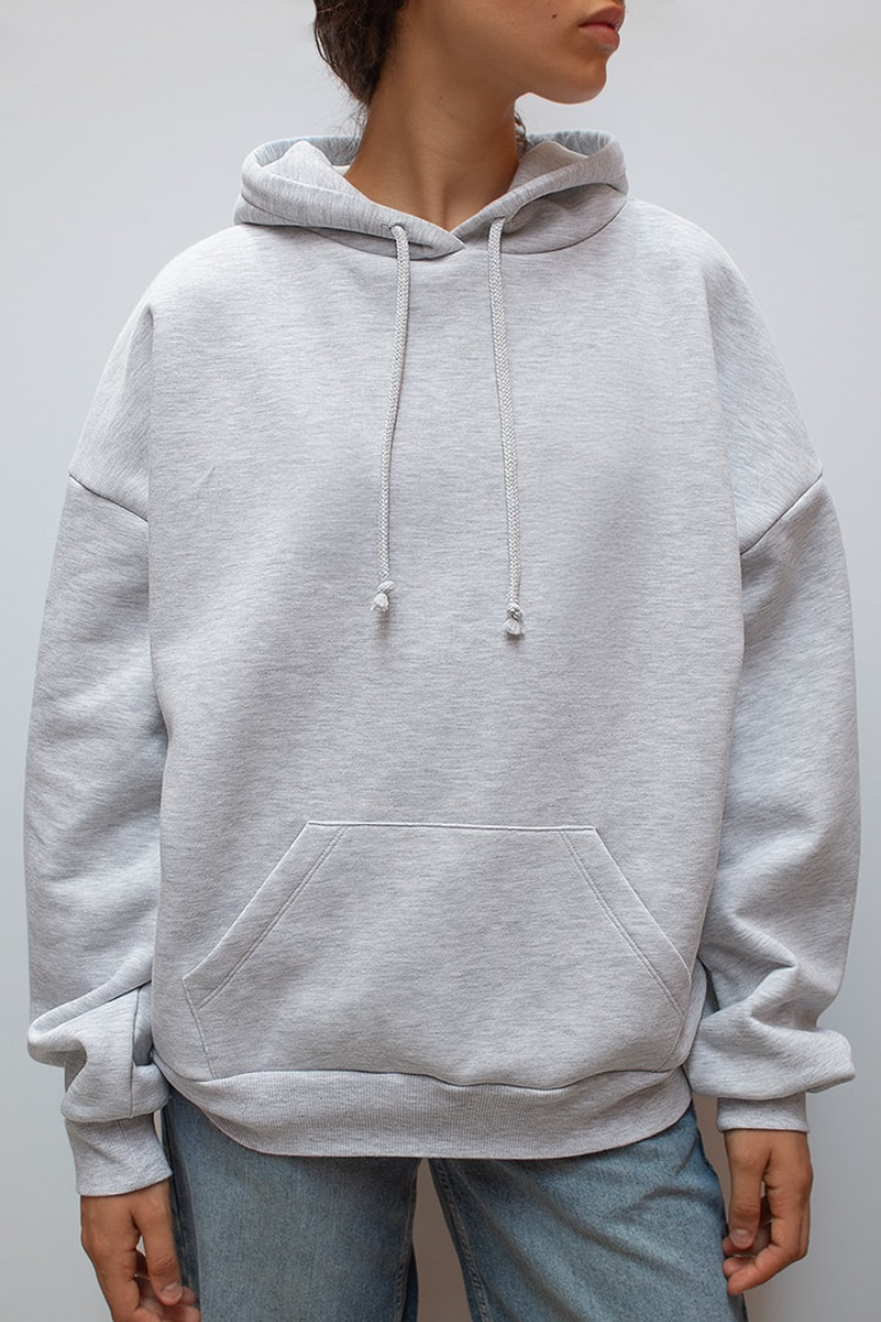 Close-up of grey hoodie front, hood and kangaroo pocket on model