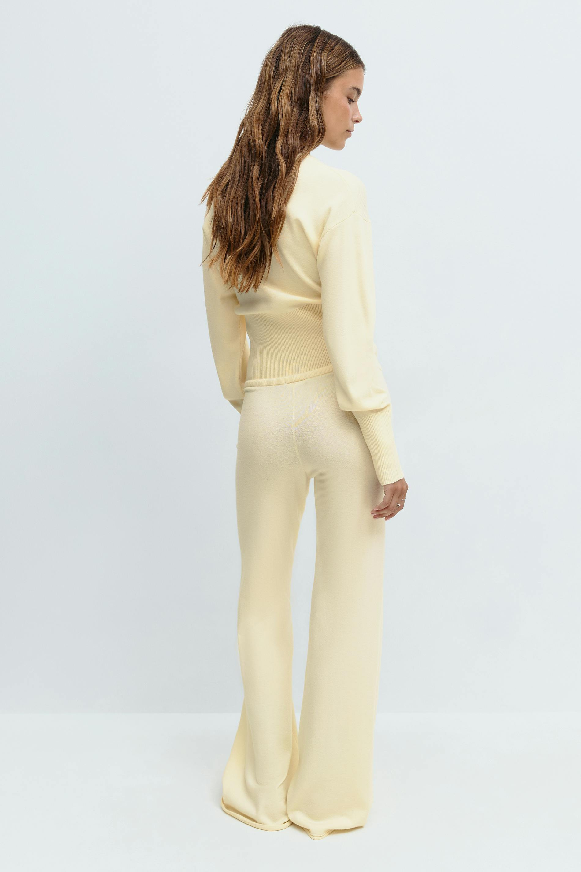 Yellow knitted cardigan and trousers set on model, back view