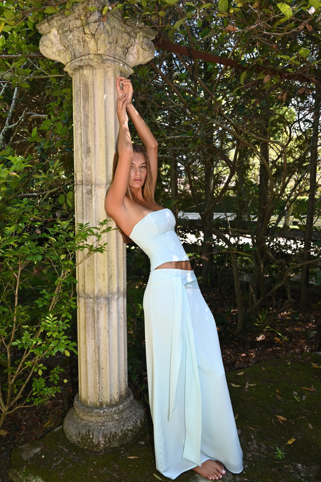 Mist blue corset top and wrap maxi skirt, side view against column