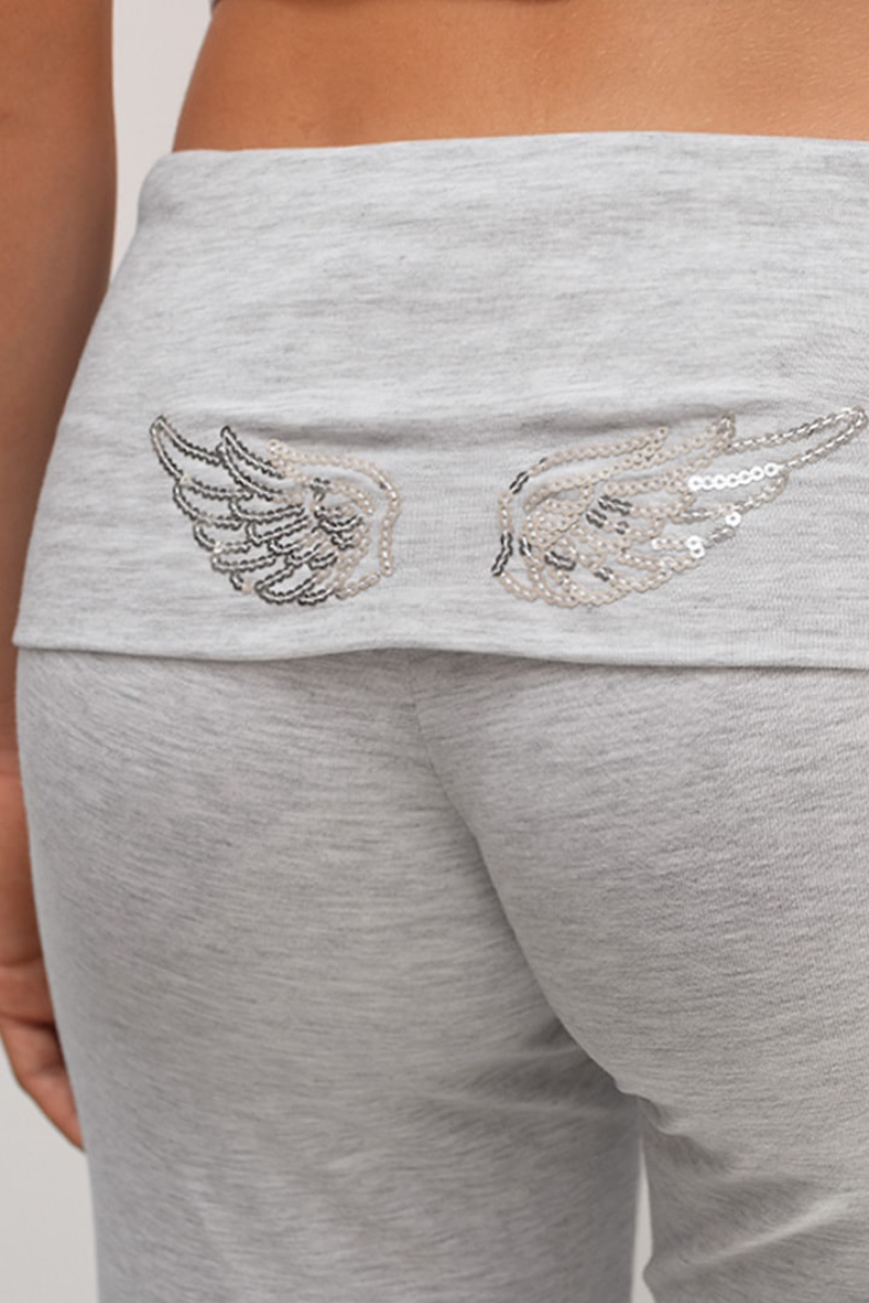 Close-up of sequin wing embroidery on grey joggers waistband