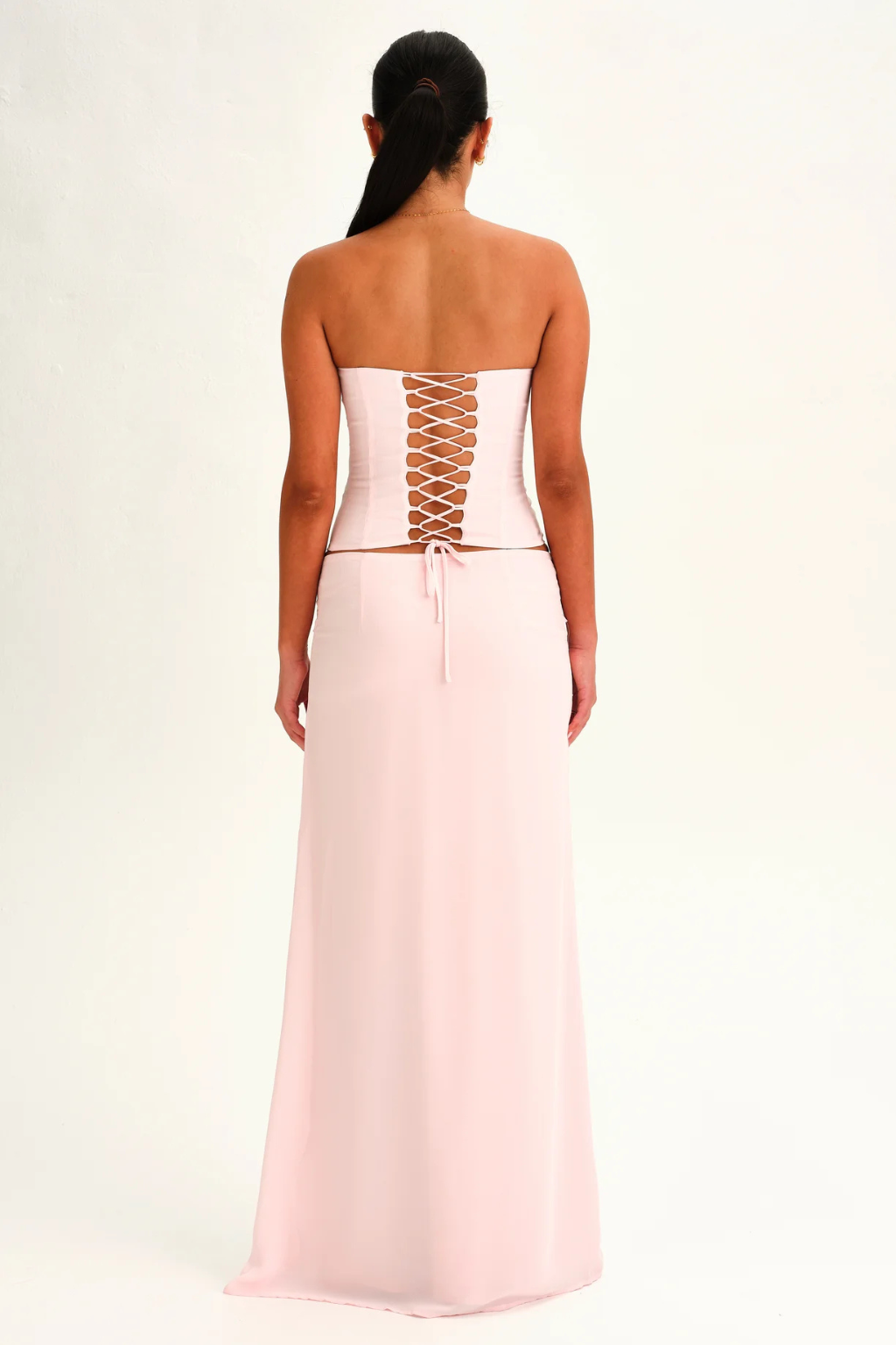 Blush pink lace-up corset top and wrap maxi skirt, back view on model