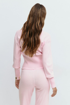 Pink knitted cardigan and trousers set, close crop back view