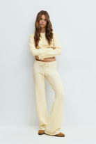 Yellow knitted cardigan and trousers set on model, front view