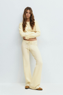 Yellow knitted cardigan and trousers set on model, front view