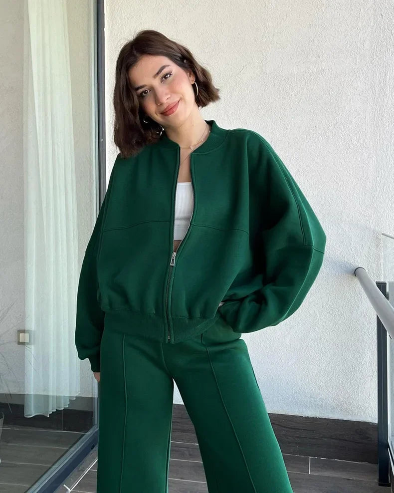 Green zip-up hoodie and joggers set, model smiling on balcony
