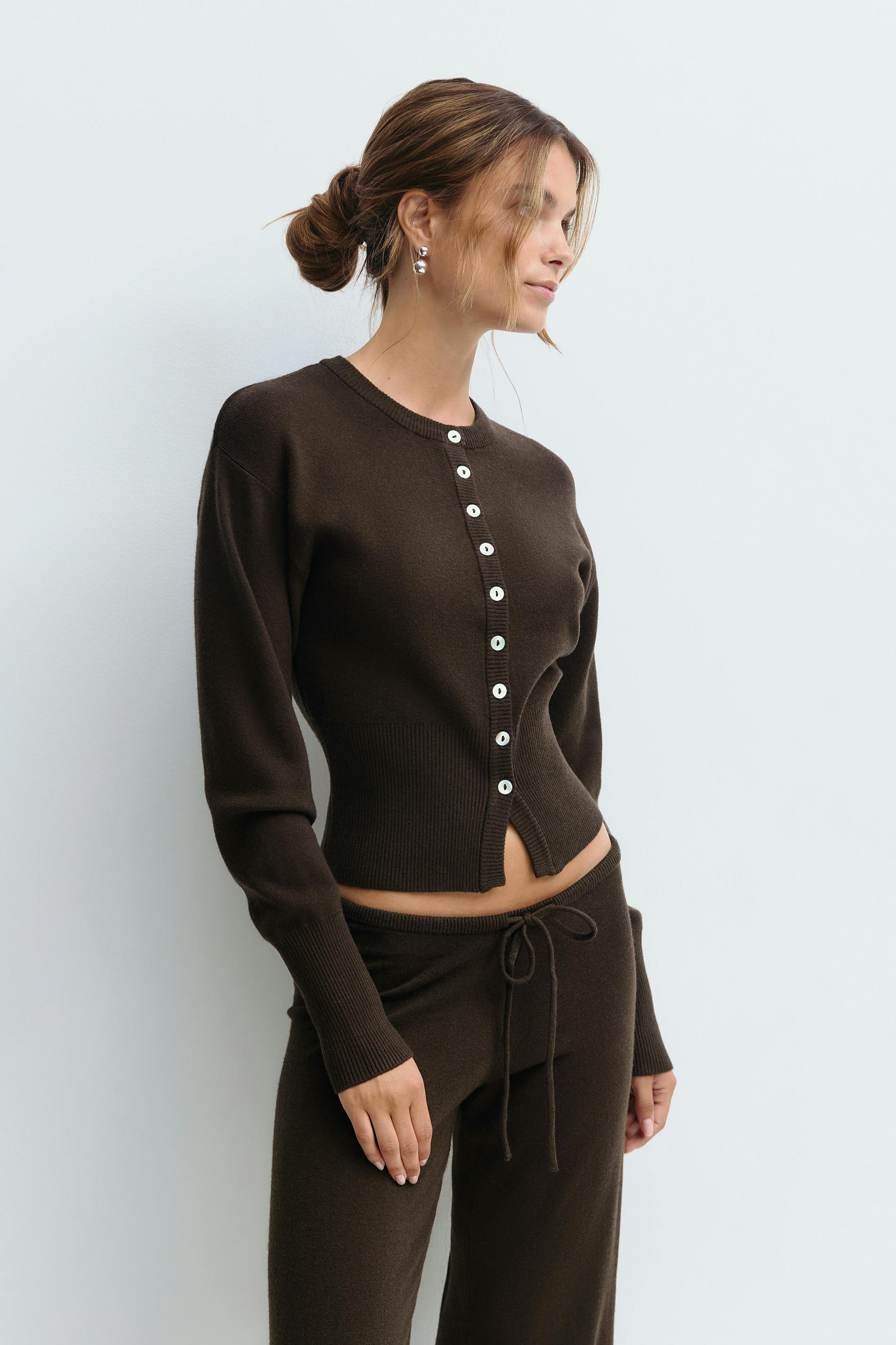 Close-up of brown knitted cardigan buttons on model