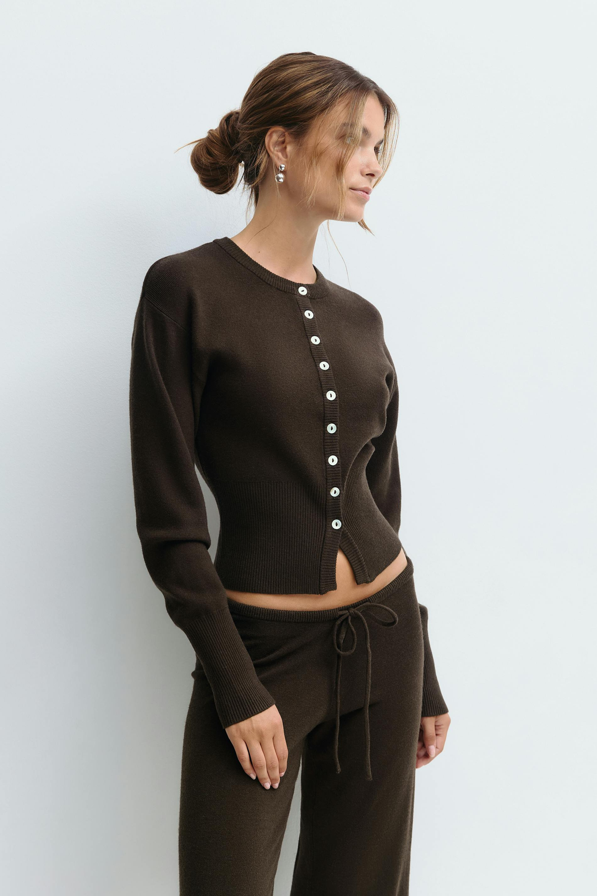 Close-up of brown knitted cardigan buttons on model