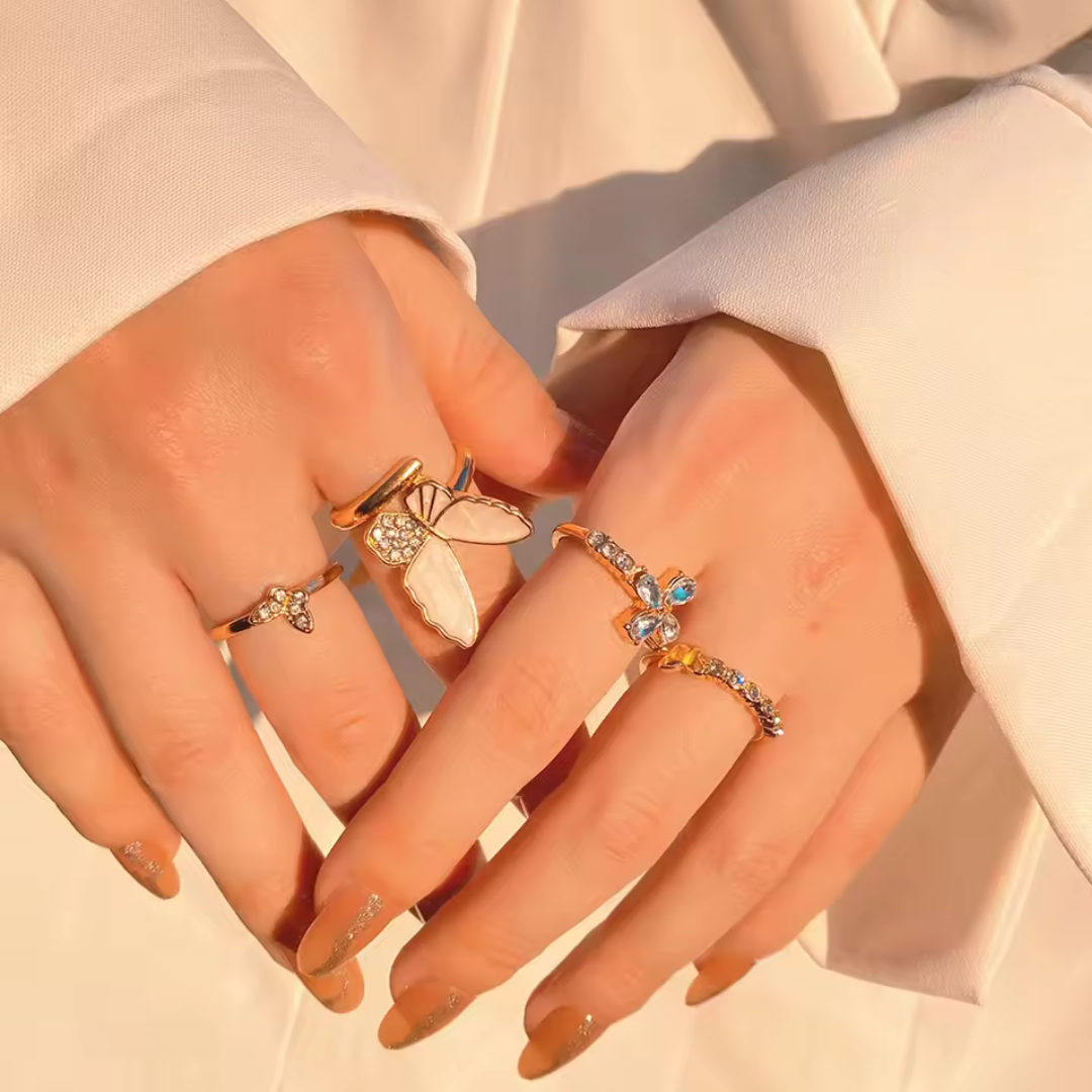 Gold butterfly ring set with crystals, close-up on model's hand