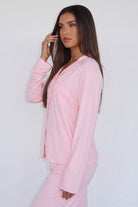 Close-up of pink pyjama shirt with chest pocket, side view on model