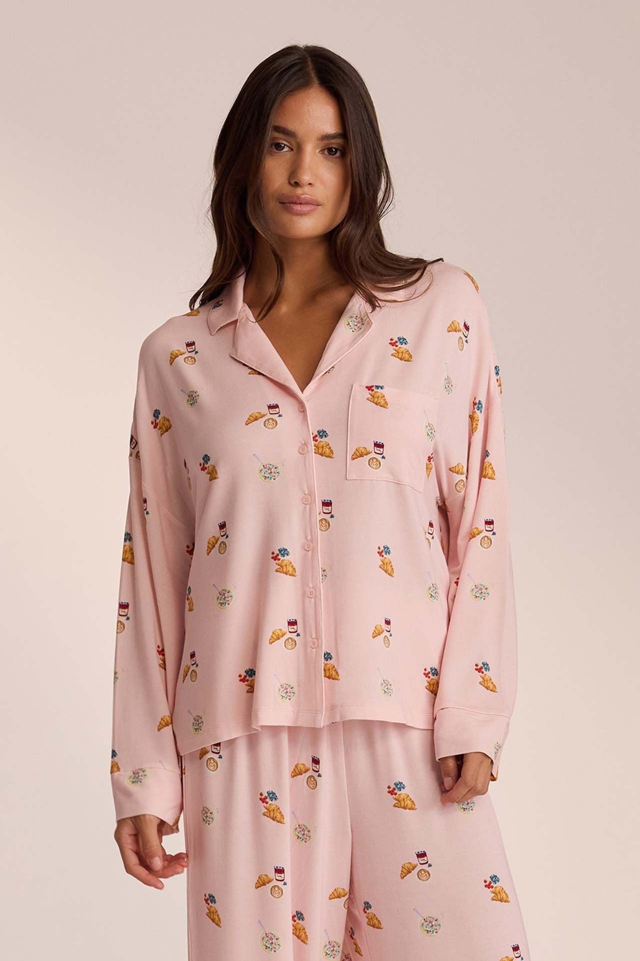 Close-up of pink breakfast-print pyjama shirt with croissant motif