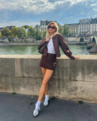Brown cropped jacket and mini skirt set, front view by river