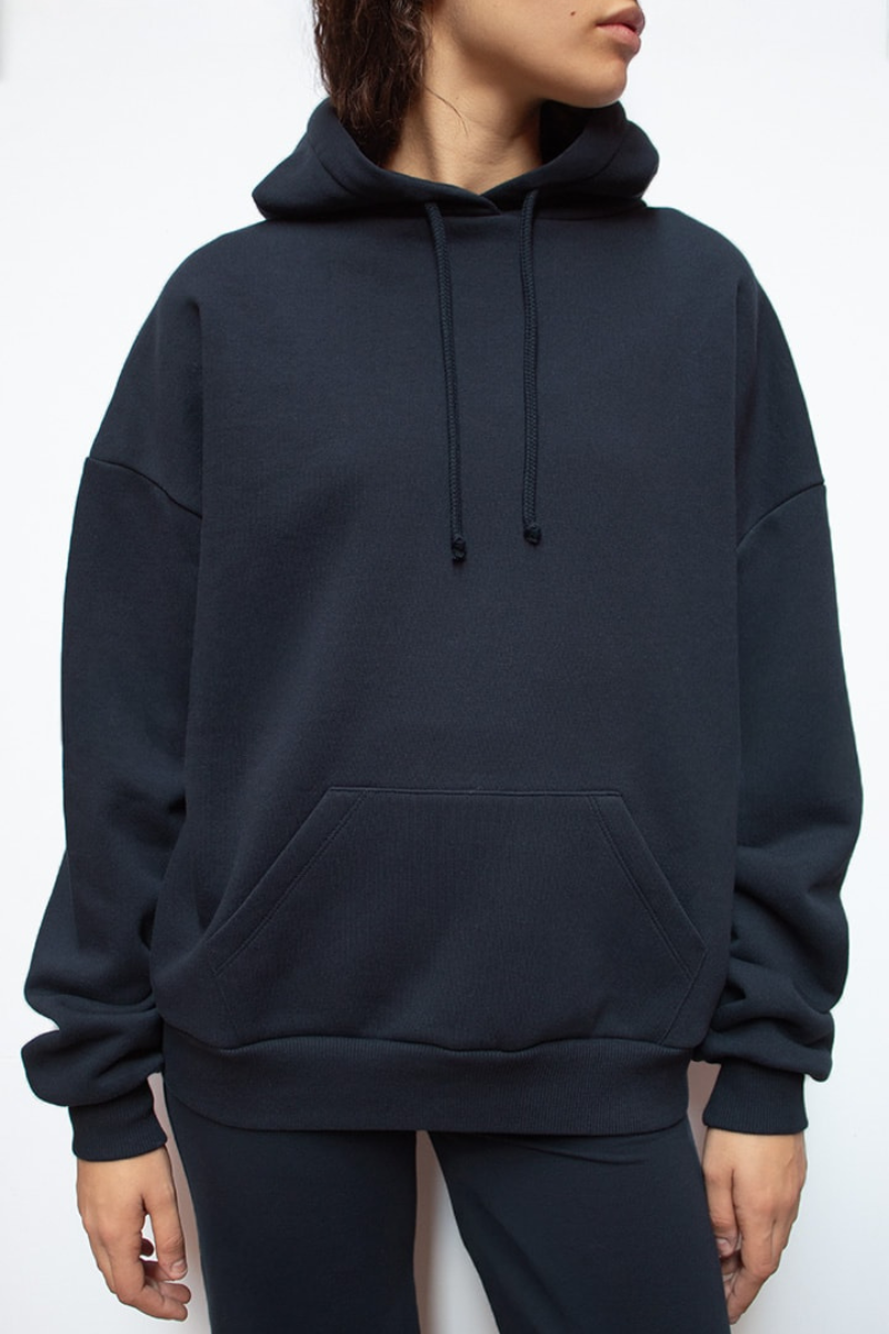 Close-up of navy hoodie front, hood and pocket on model