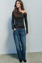 Dark grey asymmetric lace top styled with jeans, front view