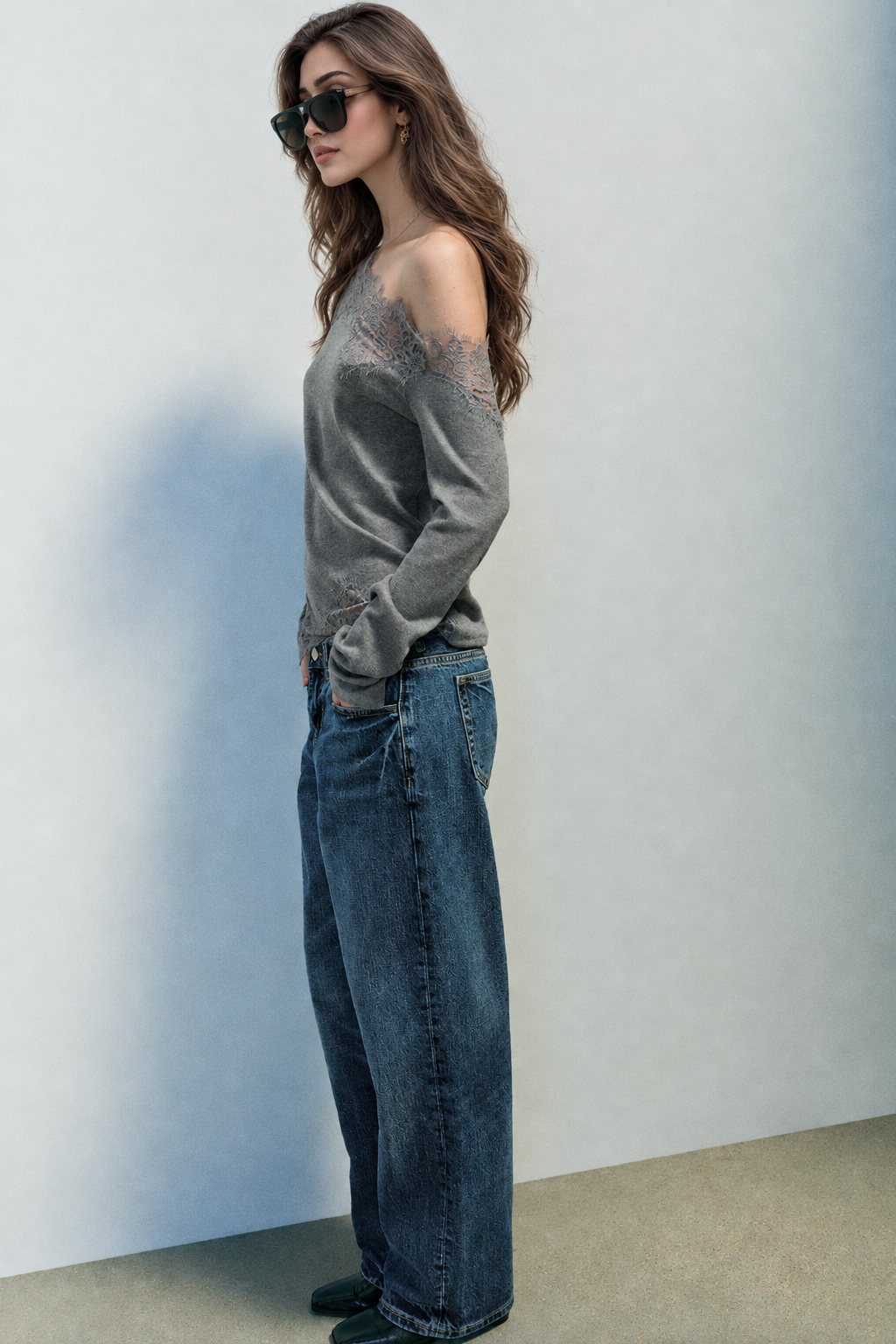 Grey asymmetric lace top styled with jeans, side view
